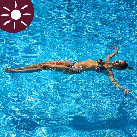 Frau im Bikini treibt entspannt im blauen Wasser des sole uno an einem sonnigen Tag